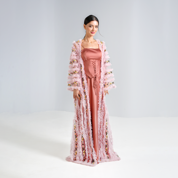 Pink abaya with floral designs, worn over a light coral corset dress